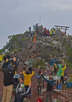 厚い雲で見えないながらも、御来光に向かって万歳する登山客たち＝１日午前４時55分、男体山山頂