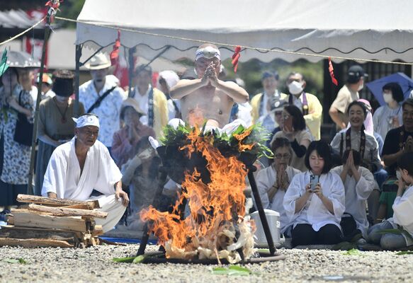 参拝者が見守る中、湯に入り経を唱える長浜住職＝28日午前、那須塩原市沼野田和

