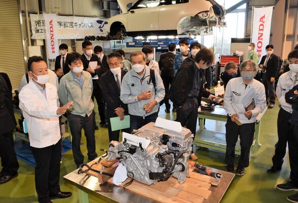 「Ｈｏｎｄａ　ｅ」の駆動用モーターなどを説明する佐藤チーフエンジニア（左）＝16日午前、宇都宮市