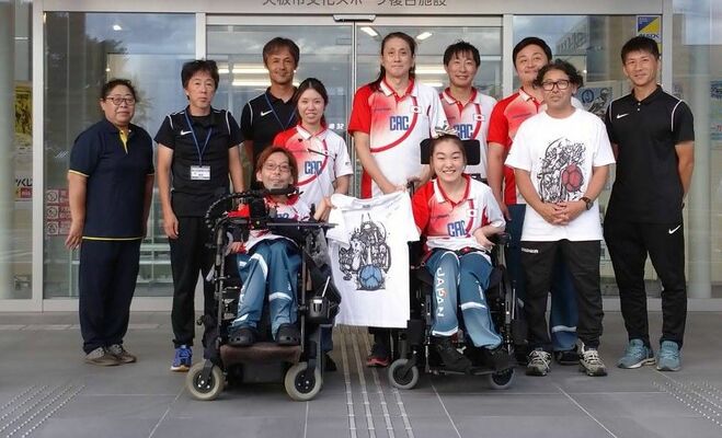 強化合宿を行い、施設関係者と記念撮影する有田選手（手前左）、一戸選手（同右）ら（市文化スポーツ複合施設提供）