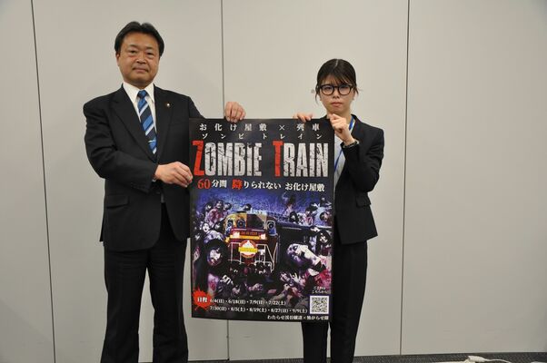 「ゾンビトレイン」のポスターを紹介する粉川市長（左）
