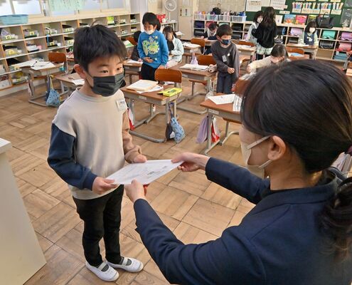 担任から通知表を受け取る児童＝２３日午前９時５５分、那須烏山市愛宕台