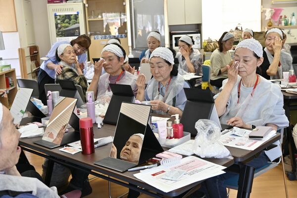 真剣な表情で鏡に向かう参加者ら