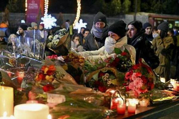 　１日、スイス南部バレー州クランモンタナの火災現場周辺で、花やキャンドルなどを手向ける人たち（ゲッティ＝共同）