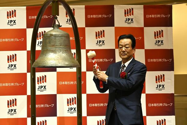 上場を祝い鐘を打つ藤川社長＝23日午後、東京都内