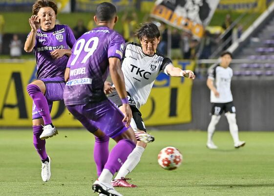 前半５分、相手と競り合う栃木ＳＣのＦＷ矢野（中央）＝藤枝総合運動公園サッカー場