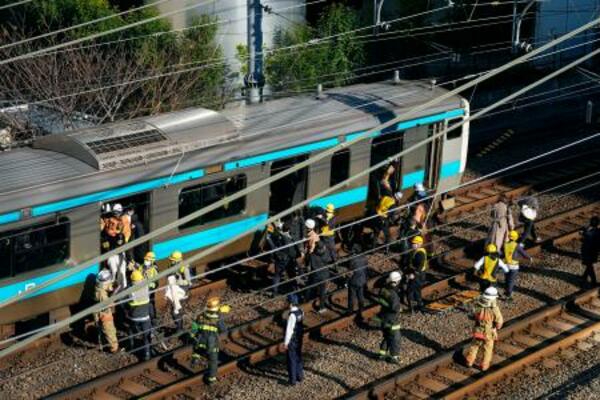 　高輪ゲートウェイ―田町間で停車したＪＲ京浜東北線の車両から線路に降りる乗客＝１６日午前９時７分、東京都港区