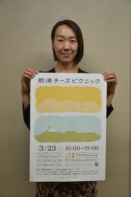 那須チーズピクニックのポスターを持つ石田主査