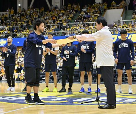 佐藤市長（手前右）から市長特別賞の賞状を受け取る田臥主将＝３１日午後、ブレックスアリーナ宇都宮