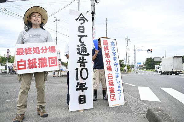 手作りの看板を持ち候補地の白紙撤回を訴える参加者＝30日午前８時40分、塩谷町玉生