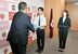 中村市長から市のポロシャツを受け取る日和田さん（中央）と小久保さん（右）