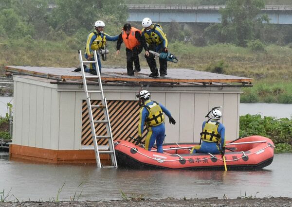 降りしきる雨の中、総合水防演習で行われた救出・救護訓練=17日午後、宇都宮市道場宿町