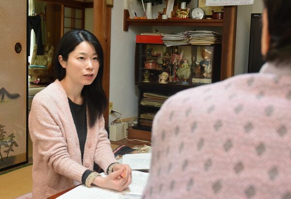 水俣病患者の自宅で聞き取りをする永野さん。「後世で二度とないように」と願い、患者の声を記録し続けている＝４月下旬、熊本県水俣市内