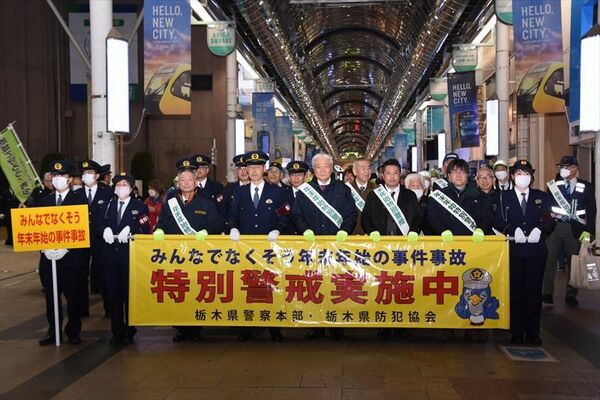 横断幕を持ってオリオン通りをパトロールする参加者たち＝８日午後６時20分、宇都宮市曲師町
