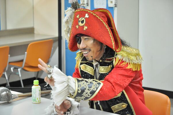 １日記者のインタビューに応じる「歌う海賊団ッ！」のキャプテン☆うっちゃるさん＝１日午後、県総合文化センター、中村寛子撮影