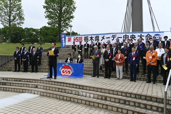県メーデー中央大会であいさつする吉成会長（手前）＝27日午前、小山市外城