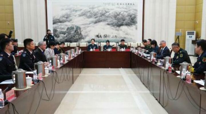 5日、中国・北京の軍事科学院で交流する自衛隊(左)と中国軍(笹川平和財団提供、共同)