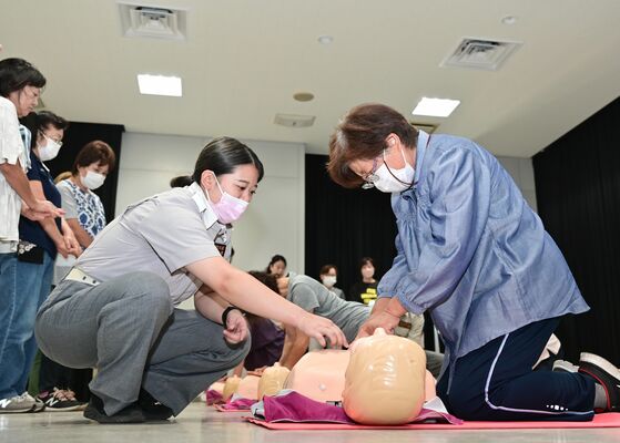救急隊員（手前左）のアドバイスを受けながら胸骨圧迫する参加者ら