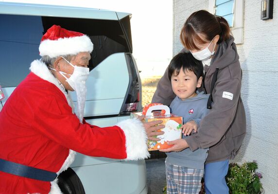 サンタからケーキを受け取る相田桃希ちゃんと母の今日子さん