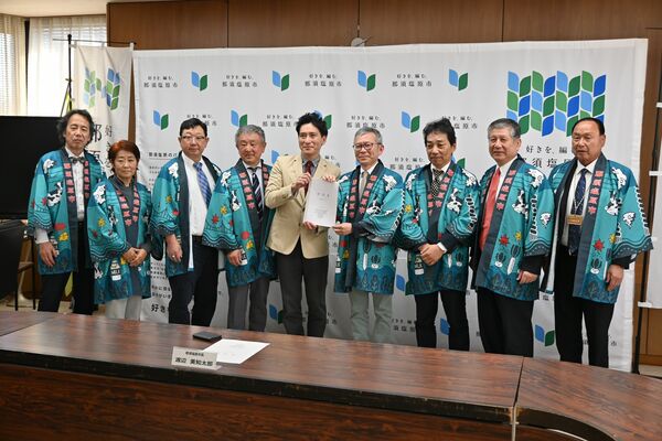 渡辺市長（左から５人目）に要望書を手渡す田代委員長（同６人目）ら検討委員会メンバー