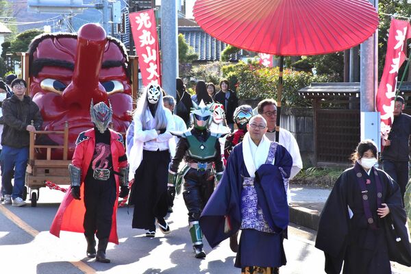 寺の門前を通る大天狗面