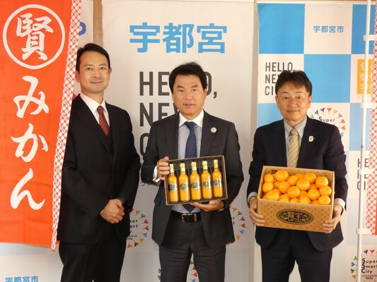 「マルケンみかん」などを手に佐藤市長（中央）を表敬した永石社長（右）と田野辺社長