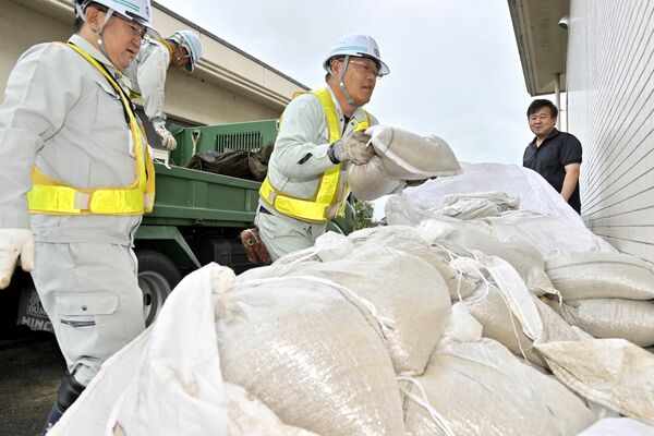 住民への配布に備え、宇都宮市瑞穂野地区市民センターに運び込まれる土のう＝16日午後１時15分、同市下桑島町