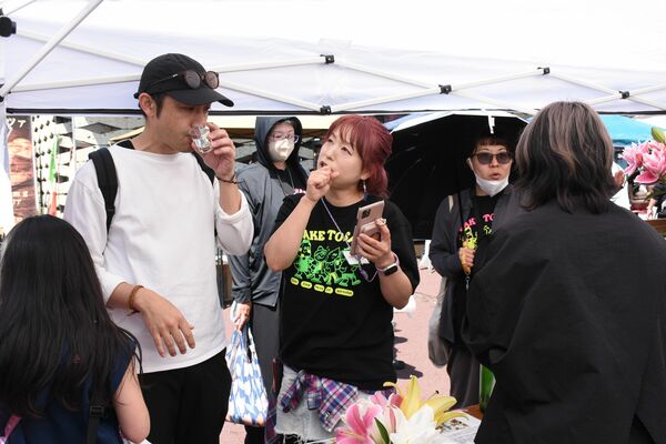 会場に訪れた知人らと会話する星絵理子さん（中央）＝４月２６日、ＪＲ宝積寺駅前