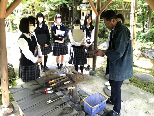 外丸代表（右）の案内で物外軒を見学し、庭師の仕事を学ぶ生徒