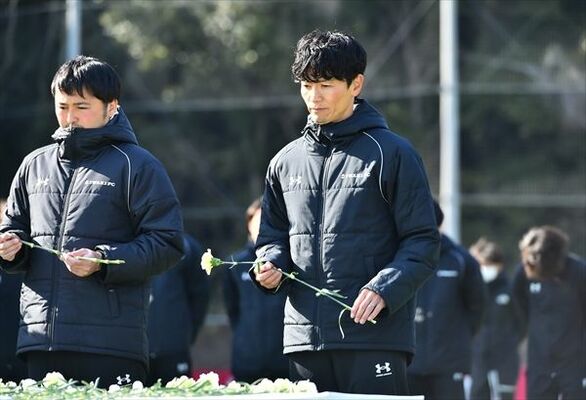 献花台に花を手向ける平松さん（中央）＝福島県いわき市のいわきＦＣフィールド