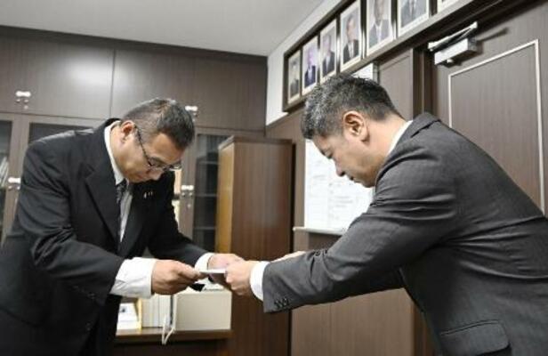 　６月、香川県東かがわ市議会に申し入れを行う上村一郎市長。左は山口大輔副議長＝香川県東かがわ市