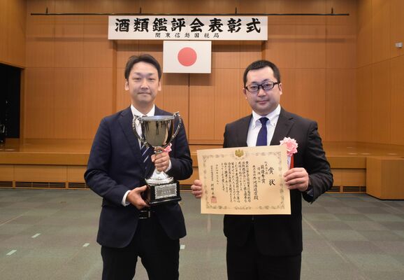 最優秀賞の受賞カップと表彰状を手にする外池酒造店の杜氏ら＝９日午後、さいたま市
