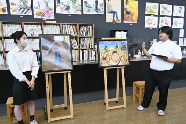 「原爆の絵」に込めた思いや制作過程を説明する福政さん（右）と樋口さん＝31日午後、広島市
