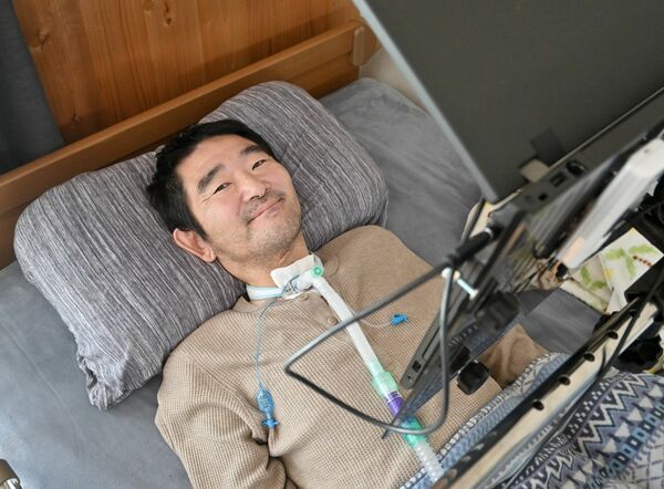 「生きる喜びを感じながら前を向いて歩んでいきたい」と、ベッドで笑顔を見せる鈴木さん＝５月上旬、宇都宮市内