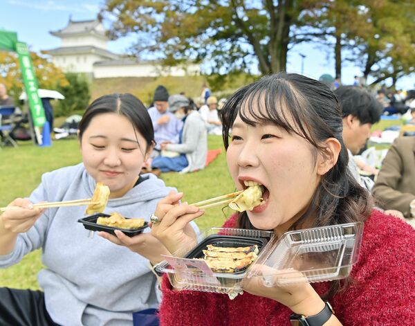 餃子をほおばる来場者=1日午前10時40分、宇都宮市本丸町