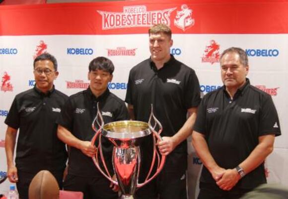 優勝カップを前に記念撮影するラグビーのリーグワン神戸を率いたデイブ・レニー氏(右端)ら=10日、神戸市