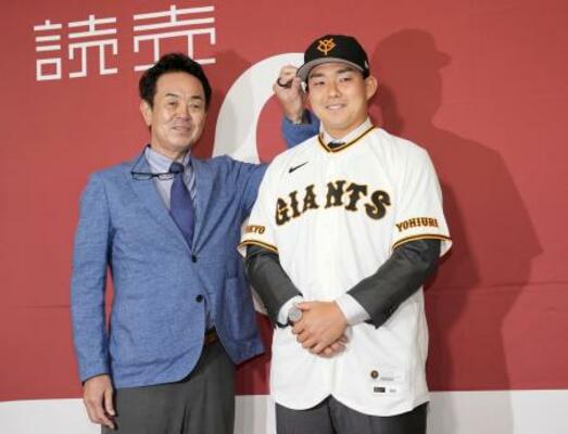 入団記者会見し、写真撮影に応じる巨人の小笠原(右)=18日、東京ドーム