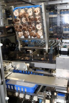 瓶栽培方式のシイタケ（上）を逆さにひっくり返し、カッターで一挙に切り取る自動収穫装置＝那珂川町