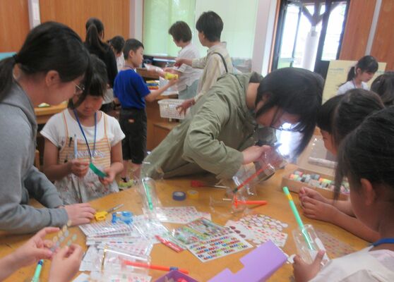 事前ワークショップで縁日のゲーム用道具を作る子どもたちと高校生ボランティア