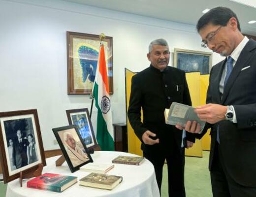 故アシャさんの関連書籍を見る小野啓一駐インド大使。左はアシャさんの次男サンジェイさん=17日、ニューデリー(共同)