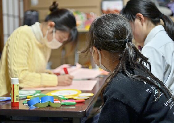 支援者のサポートの先でつながった「月の家」で過ごす舞さん（手前）。この日は他の子どもの誕生日会の準備を手伝った＝３月上旬、宇都宮市内