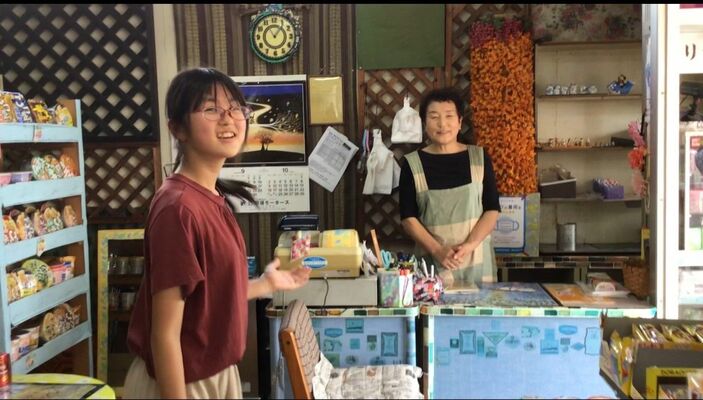 訪問先の商店でリポートする黒田原小の児童