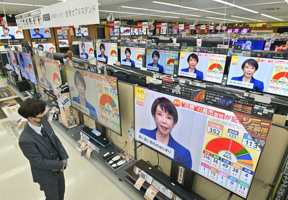 家電量販店で高市首相の記者会見を伝えるテレビに目を向ける来店客＝９日午後６時５分、宇都宮市元今泉３丁目