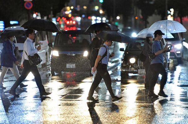 台風13号の影響で雨が降る中、傘を差して足早に歩く人たち。宇都宮市内では夜まで断続的に雨が続いた。帰宅時間帯のＪＲ宇都宮駅近くでは、足元に気をつけながら歩く姿があった＝８日午後６時20分、宇都宮市駅前通り１丁目