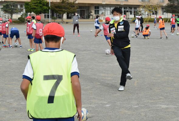 児童とパスの練習をする福森選手（奥）