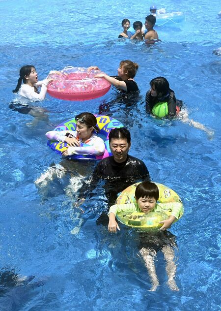 梅雨明けの青空の下、波のプールを楽しむ親子たち＝18日午後、真岡市下籠谷