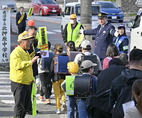 警察官や関係者に見守られながら登校する北押原小児童＝17日午前７時30分、鹿沼市樅山町、森田大地撮影