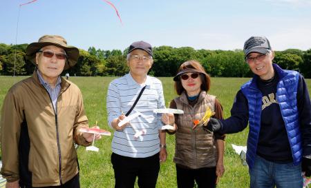 オリジナルの紙飛行機を手にする永井義章さん(左端)ら=東京都葛飾区