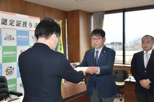 認定証を受け取る前田社長（中央）