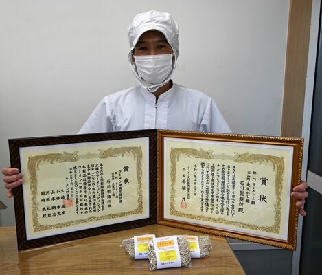 Ｗ受賞した「麦焦がし麺」と賞状を手にする石川さん